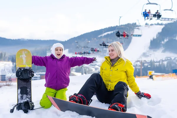 Mère et fille avec des snowboards jouent dans la neige — Photo