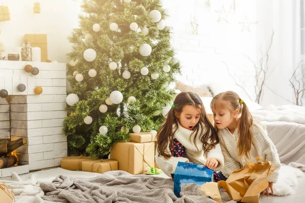 Kinder kleine Schwestern halten Geschenkboxen im Inneren Hintergrund. Was für eine große Überraschung. kleine süße Mädchen erhielten Weihnachtsgeschenke. Die besten Spielzeuge und Weihnachtsgeschenke. Kinderfreunde beim Auspacken ihrer Geschenke begeistert. — Stockfoto