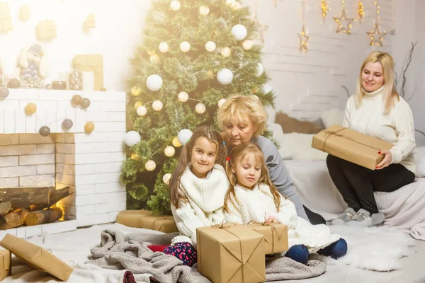 Familie ruilt geschenken uit voor de kerstboom — Stockfoto