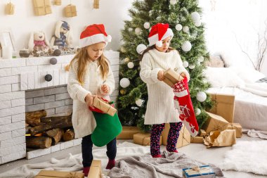 Çocuklar küçük kız hediye kutuları iç arka plan tutun. Ne büyük bir sürpriz. Küçük şirin kızlar tatil hediye aldı. En iyi oyuncaklar ve Noel hediyeleri. Çocuk arkadaş onların hediyeler açma heyecanlı.