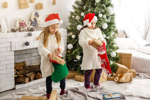 Kinder kleine Schwestern halten Geschenkboxen im Inneren Hintergrund. Was für eine große Überraschung. kleine süße Mädchen erhielten Weihnachtsgeschenke. Die besten Spielzeuge und Weihnachtsgeschenke. Kinderfreunde beim Auspacken ihrer Geschenke begeistert. — Stockfoto