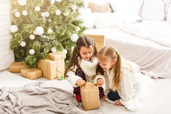 Kinder kleine Schwestern halten Geschenkboxen im Inneren Hintergrund. Was für eine große Überraschung. kleine süße Mädchen erhielten Weihnachtsgeschenke. Die besten Spielzeuge und Weihnachtsgeschenke. Kinderfreunde beim Auspacken ihrer Geschenke begeistert. — Stockfoto