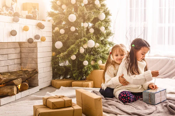 Kinder kleine Schwestern halten Geschenkboxen im Inneren Hintergrund. Was für eine große Überraschung. kleine süße Mädchen erhielten Weihnachtsgeschenke. Die besten Spielzeuge und Weihnachtsgeschenke. Kinderfreunde beim Auspacken ihrer Geschenke begeistert. — Stockfoto