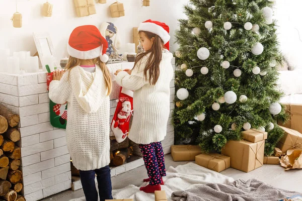 Zusjes van jonge geitjes houden geschenken vakken interieur achtergrond. Wat een geweldige verrassing. Kleine schattige meisjes ontvangen giften van de vakantie. Beste speelgoed en Kerstcadeaus. Kinderen vrienden enthousiast hun Cadeaus uitpakken. — Stockfoto