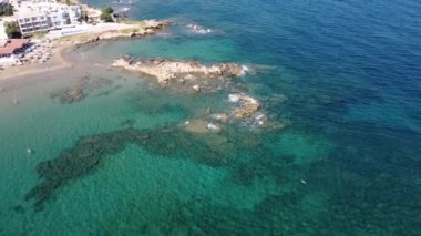 İnsansız hava aracının su altı resiflerindeki görüntüsü ve Akdeniz kıyısındaki şeffaf suyla birlikte plajların yakınındaki kayalıklar. Kamera aşağı bakıyor. Girit, Yunanistan.