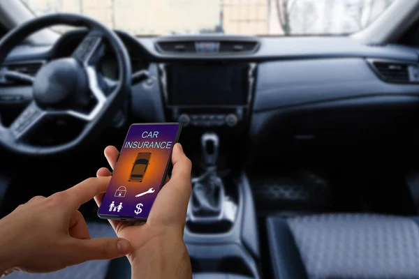 壊れた車の後にオンラインで自動車保険のアプリケーションを使用するためにスマートフォンを保持ハンサムな男の手。保険の概念. — ストック写真