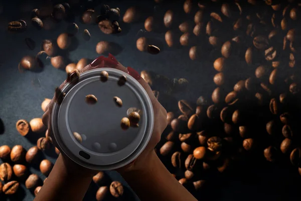 Kaffepapper koppar med kaffebönor på en mörk bakgrund. Mönster och kreativ bakgrund koncept för kaféer. — Stockfoto