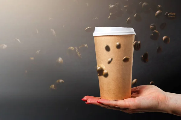 Kaffepapper koppar med kaffebönor på en mörk bakgrund. Mönster och kreativ bakgrund koncept för kaféer. — Stockfoto