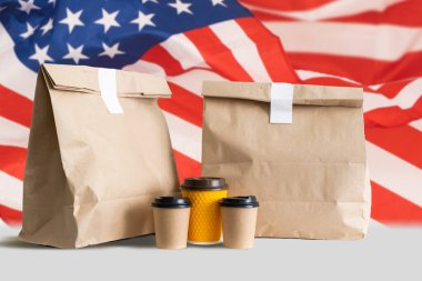 ABD bayrağının arka planında paketler var. Çevrimiçi İthalat İhracat veya eCommerce dağıtım mağazası ürün taşımacılığı, ticaret, tedarikçi kavramı.