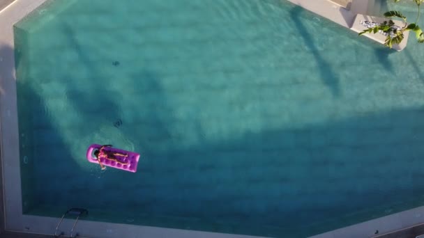 Niña flota en un colchón inflable en la piscina — Vídeos de Stock