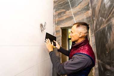 Bina, tadilat, teknoloji ve insan kavramı - yakın Oluşturucusu'nu veya işçi el ile tablet pc bilgisayar.