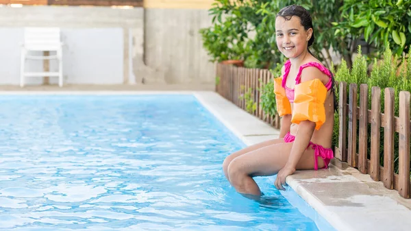 Glückliches kleines Mädchen hat Spaß im Pool im Badeanzug. — Stockfoto