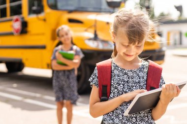 Okul otobüsüne koşan sevimli öğrenciler.