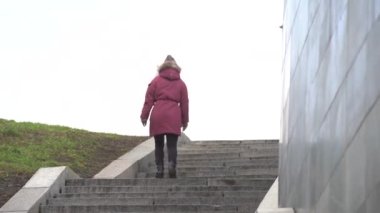 Meydan okuyan bir kadın. Kadın basamakları tırmanıyor.