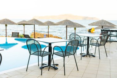 Boş masa üstü ve bulanık yüzme havuzu, tropikal tatil beldesinde, afiş arka planında.