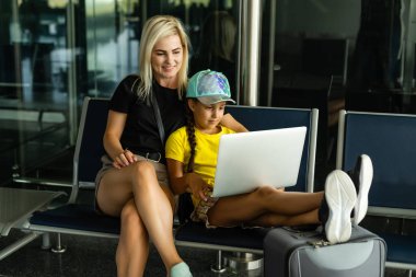 Laptop havaalanında çalışan anne kız.