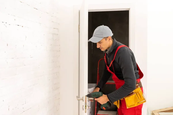 Young man fixing the door with screwdriver — Stock Photo, Image
