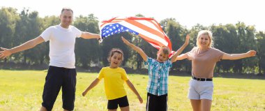 Amerika ve Amerikan bayrağı altında mutlu bir aile.