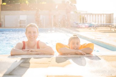 Mutlu anne ve kız eğlence merkezindeki yüzme havuzunda.