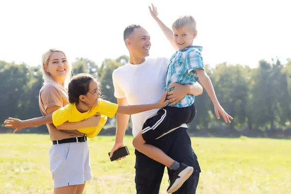Boldog család játszik a zöld mezőn — Stock Fotó