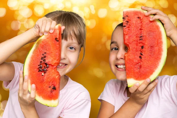 Двоє дітей їдять один шматочок кавуна. Діти їдять фрукти на відкритому повітрі. Здорові закуски для дітей . — стокове фото