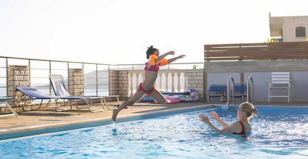 Mãe e filha brincando em uma piscina — Fotografia de Stock