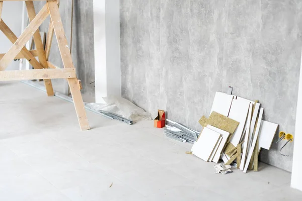 Reparatie in het appartement. bouwschilders geit in het interieur van een lichte kamer met frisse gepleisterde muren. Witte muren in een gebouw bouwhuis. — Stockfoto
