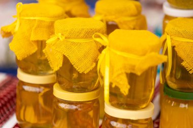 Tarafsız pastel arka planda cam bal kavanozuyla kompozisyon. Alternatif tıp, önleyici tıp.