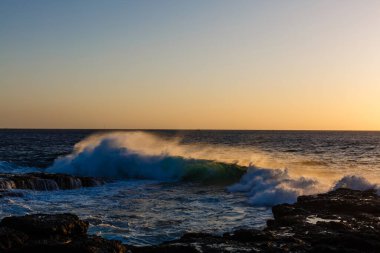 Alacakaranlıkta taşları olan sakin deniz kıyıları, doğal deniz arka planı.