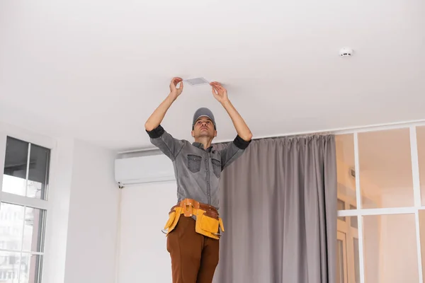 전기 기술자는 전기 램프를 아파트 안에 설치 한다. 건축 장식 개념. — 스톡 사진