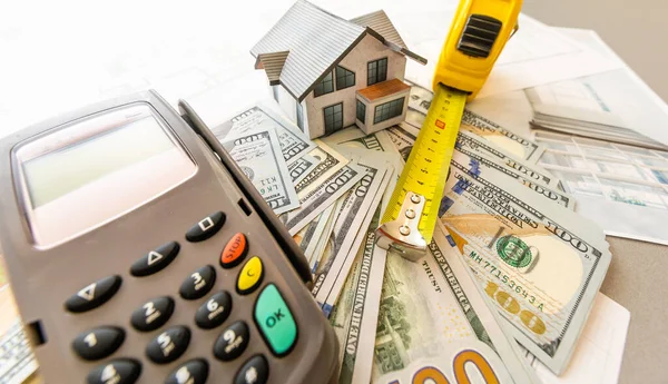 Modello in miniatura di casa sullo sfondo di un piano di casa, e denaro, e calcolatrice. — Foto Stock
