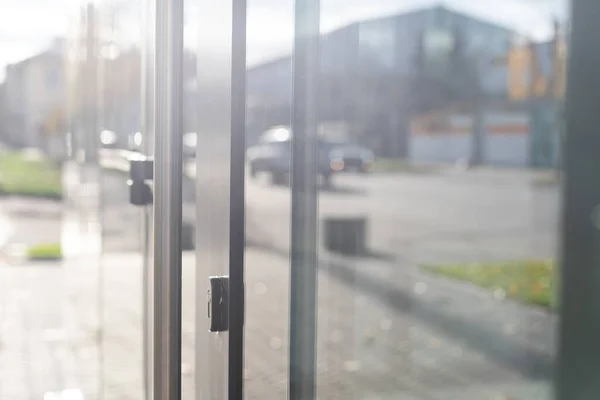 The front door of a office block, reflecting buildings in the glass — Stock Photo, Image