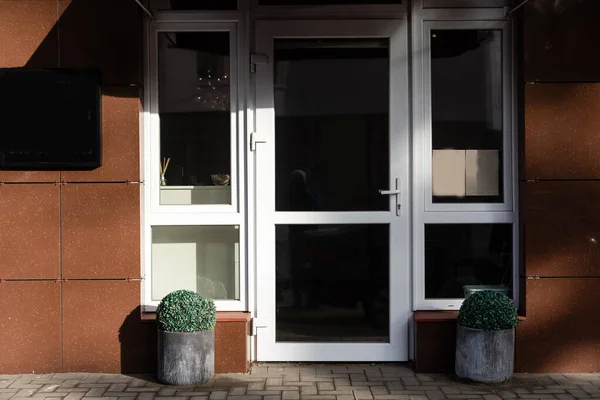 De voordeur van een kantoorgebouw, reflecterende gebouwen in het glas — Stockfoto