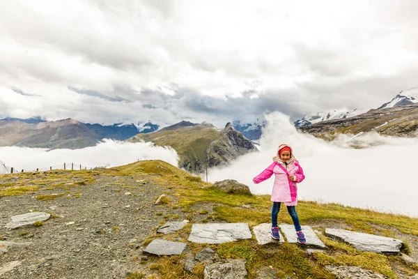 Дети путешествуют в горах Альп. Дети смотрят на горы в Австрии. Весенний семейный отдых. Веселье и здоровый образ жизни на свежем воздухе. — стоковое фото