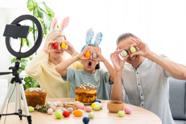 Aile, Paskalya tatilinde arkadaşlarıyla özel bir program kullanarak internet üzerinden iletişim kurar. İş arkadaşlarına tablet üzerinden video konferansı. Çiçekler ve renkli yumurtalarla süslenmiş bir masa.