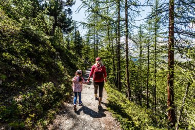 Anne ve çocuklar dağ çevresinde yürüyüşe çıkıyorlar..