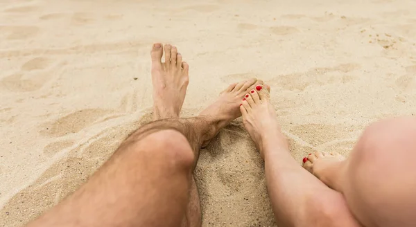 Closeup of feet row lying in line at summer beach — Stock Photo, Image