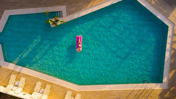 Mujer bonita joven en el colchón de aire en la piscina — Foto de Stock