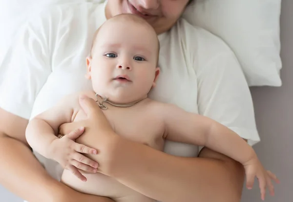 Boldog mosolygó anya és a baba feküdt az ágyon otthon — Stock Fotó