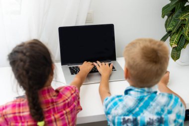 Tatlı çocuklar eğitim için dizüstü bilgisayar, online çalışma, evde öğrenim, uzaktan öğrenim gören kız ve erkek çocukları. Evde eğitim için yaşam tarzı kavramı.