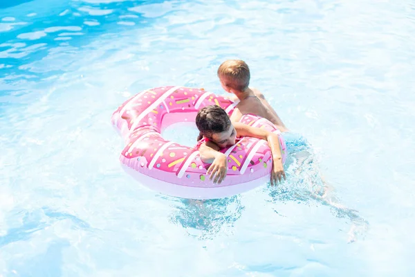 Niños divirtiéndose jugando en la piscina en las vacaciones de verano — Foto de Stock