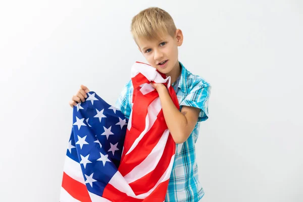 Blonde boy waving national USA flag outdoors over white background. American flag, patriotism, independence day 4th july concept — Stock Photo, Image