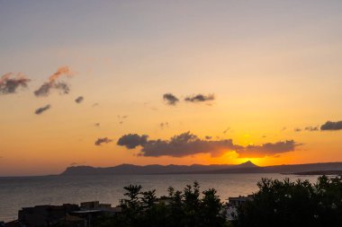 Karadeniz 'de gün batımında muhteşem bir manzara ve üzerinde muhteşem bir güneş ışığı olan turuncu gökyüzü arka plan olarak sakin dalgaların üzerinde. Sahilde inanılmaz yaz gün batımı manzarası