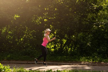 Genç fitness kadın atlet yolda koşuyor.