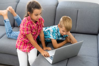Tatlı çocuklar eğitim için dizüstü bilgisayar, online çalışma, evde öğrenim, uzaktan öğrenim gören kız ve erkek çocukları. Evde eğitim için yaşam tarzı kavramı.