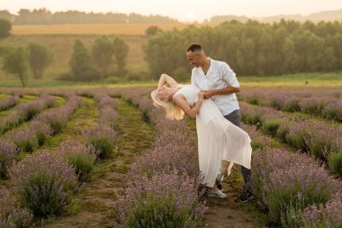 Lavanta tarlasında durup kucaklaşan sevgi dolu bir çift.