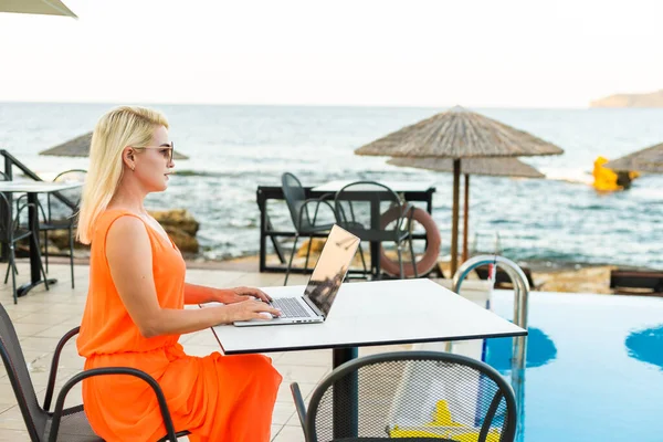 Όμορφη γυναίκα των επιχειρήσεων που εργάζονται σε απευθείας σύνδεση σε φορητό υπολογιστή, ενώ βρίσκεται στην παραλία Lounger. Freelancer κορίτσι χαλαρώνοντας και χρησιμοποιώντας Notebook εργασίας στο Διαδίκτυο. Τεχνολογία επικοινωνιών. — Φωτογραφία Αρχείου