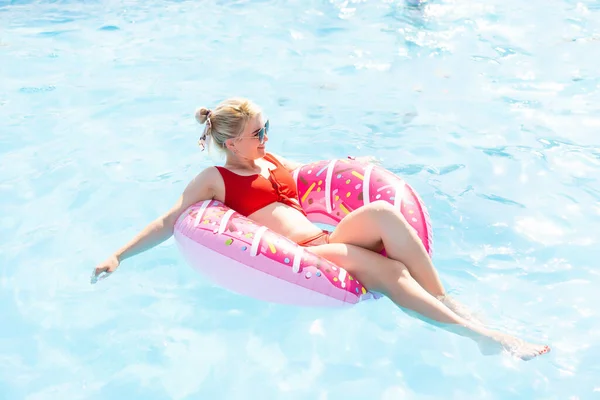 Kobieta relaksująca się na pączkowej lilii w basenie w prywatnej willi. Nadmuchiwany pierścień i materac. Letnie wakacje idylliczny. Widok z góry — Zdjęcie stockowe