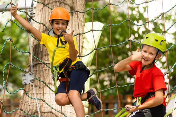 Feliz niño trepando a los árboles. Parque de cuerdas. Niño escalador. Desarrollo de la primera infancia. Parque de cuerdas. Puentes de cuerda y viga de equilibrio. Parque de cuerdas - centro de escalada — Foto de Stock