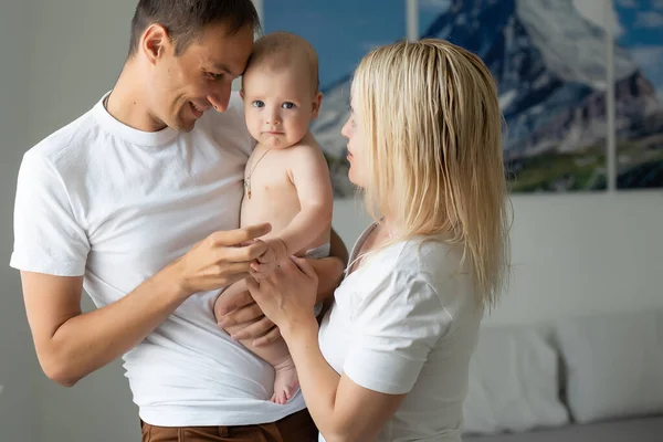 Medelålders föräldrar med barn i vitt sovrum — Stockfoto